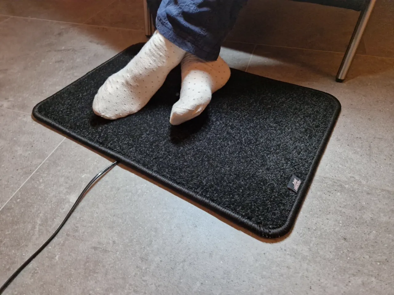 Zwarte verwarmde voetenmat met 2 meter stekkersnoer en aan/uit-schakelaar