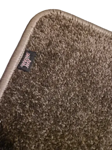 Close-up taupe verwarmde voetenmat: zachte hoogpolige tapijtstructuur