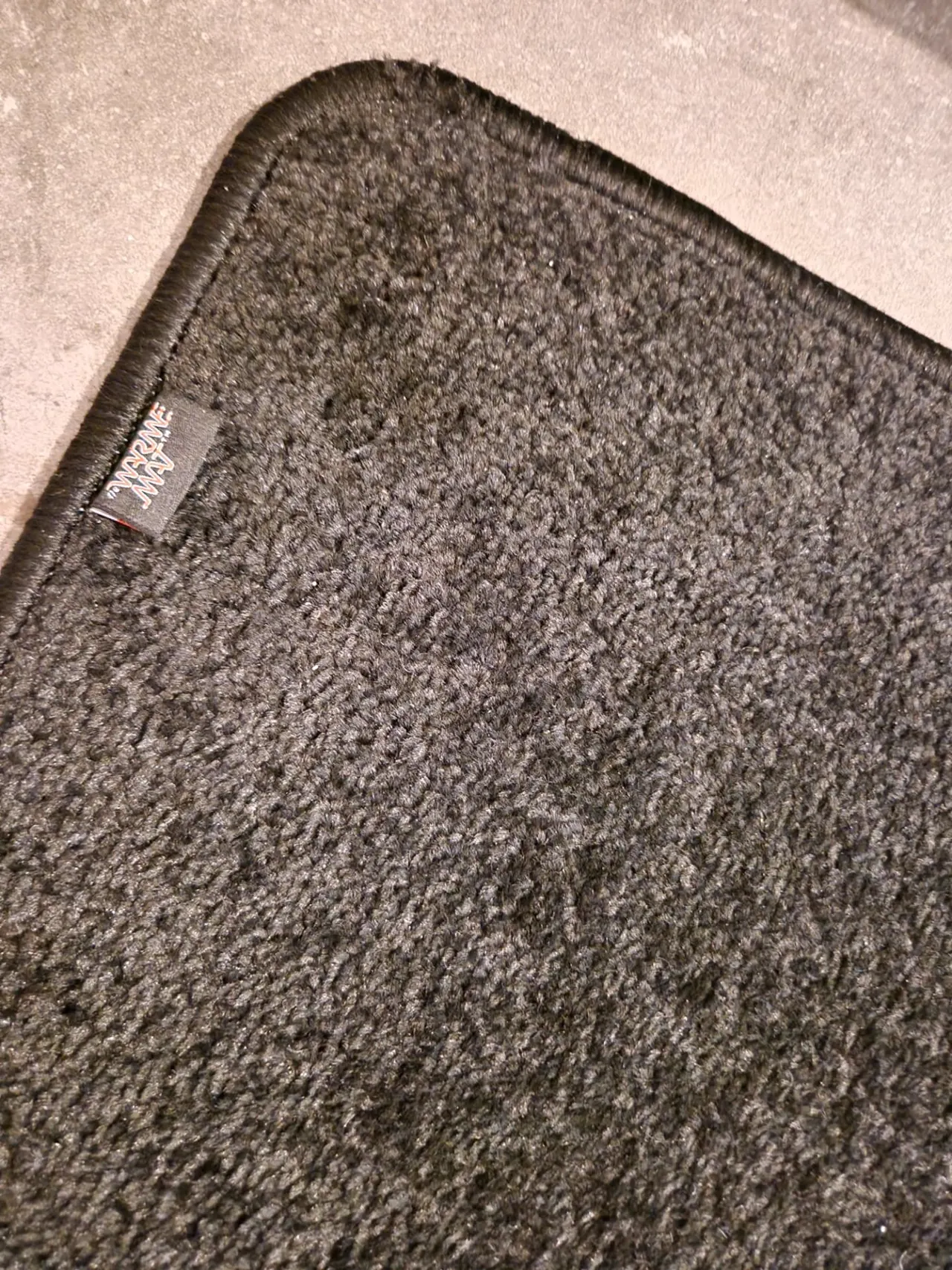Close-up hoogpolig fluweelzacht tapijt van de verwarmde voetenmat met De WarmeMat™-label